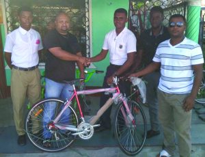 Alex Algoo receives a bicycle from Steve Ramdatt of Mara and Sons