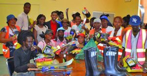 Community Infrastructure Improvement Project workers pose with the various tools, safety equipment and cleaning agents they received