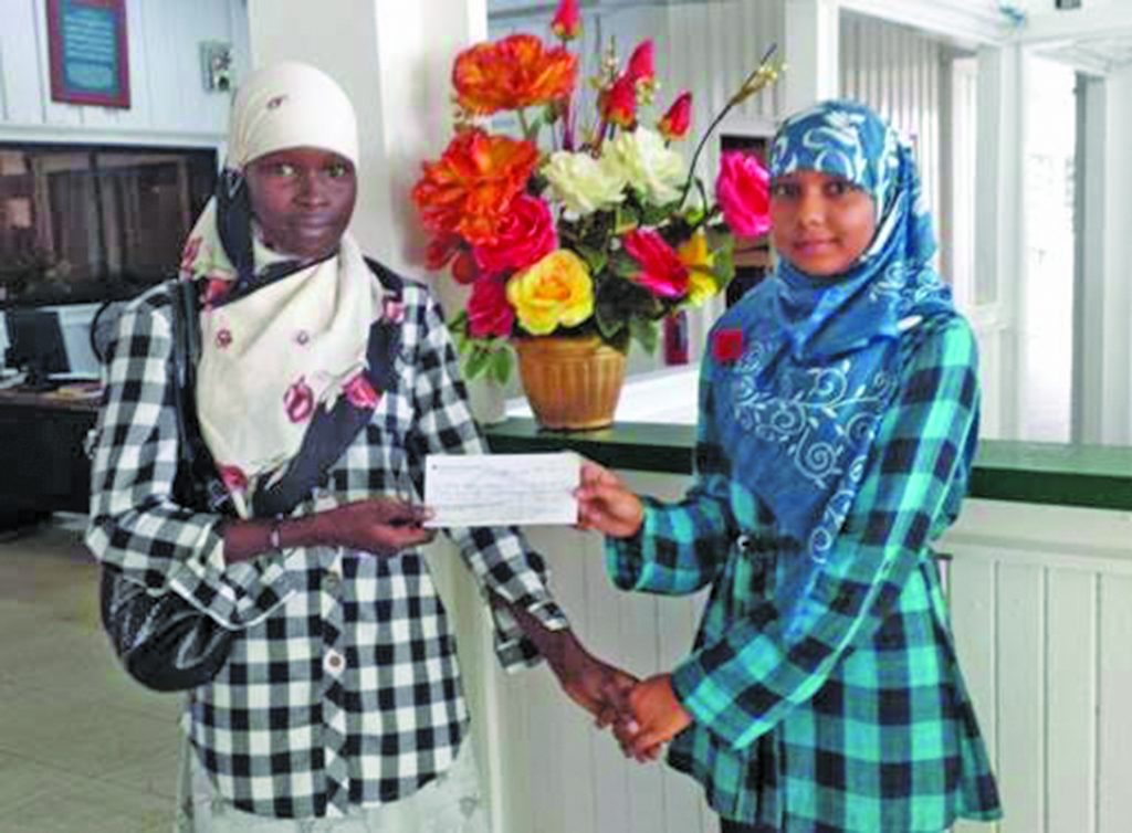 A staff (right) of the CIOG hands over a cheque to Maryam Bristol’s mother (left)