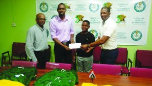 Director of Sport Christopher Jones hands over the cheque to Ninvalle in the presence of Coach Linden Johnson(left) and GTTA President Godfrey Munroe