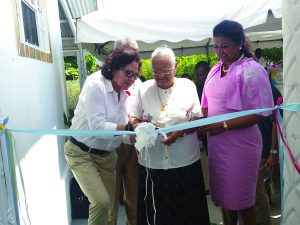 First Lady Sandra Granger, Guyana Foundation President Surpriya Singh-Bodden and an elderly citizen cutting the ribbon