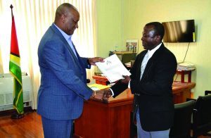 Retired Brigadier Edwards Collins presenting the preliminary report to Minister of State, Joseph Harmon