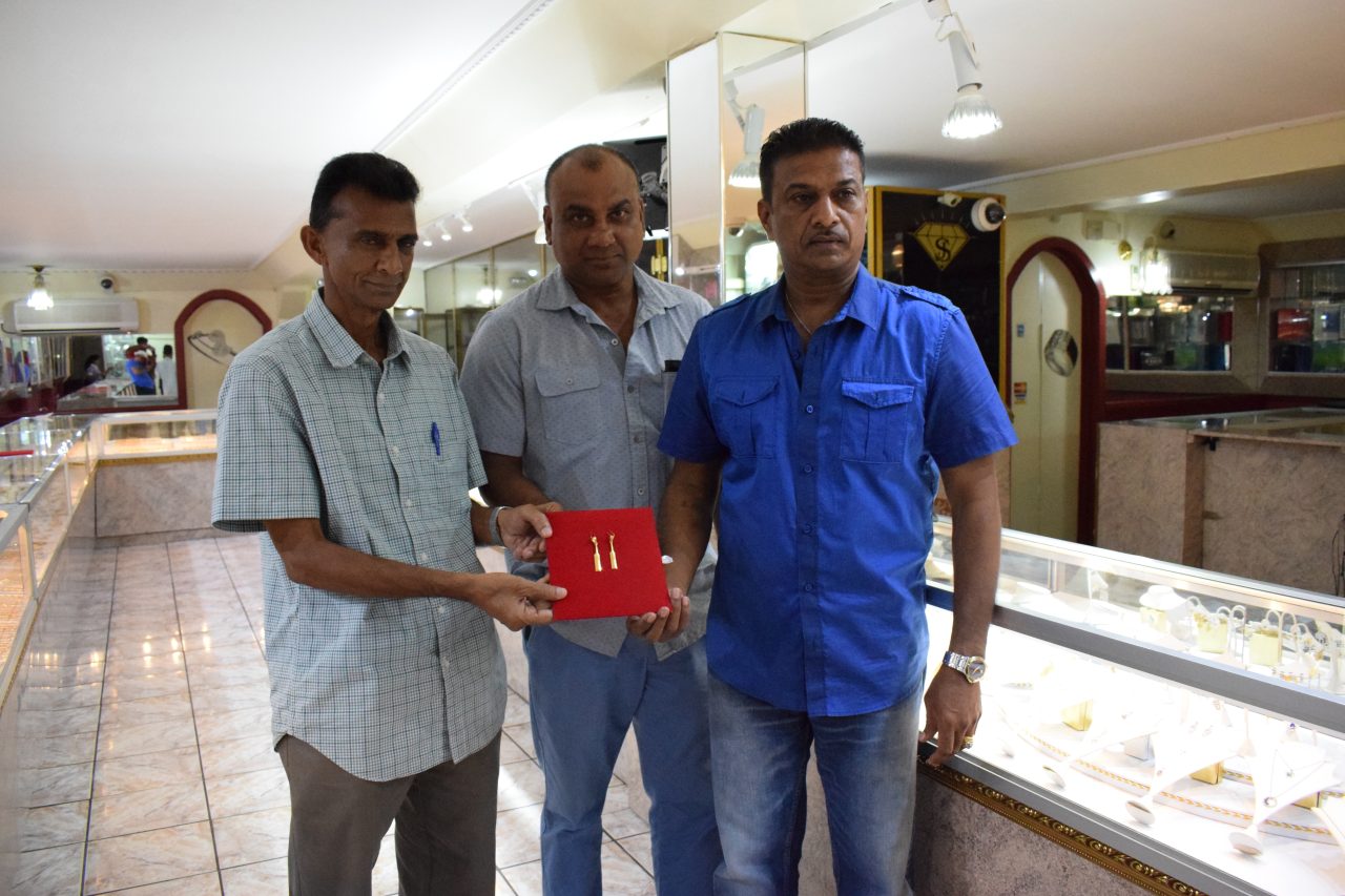 Manager of Steve’s Jewellery, Steve Narine hands over the hand-crafted prized possessions to Dharam Persaud (left) and Ricky Deonarain