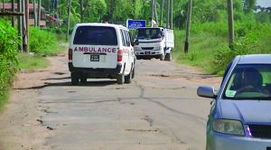 An ambulance and Canter manoeuvring on the appalling road  