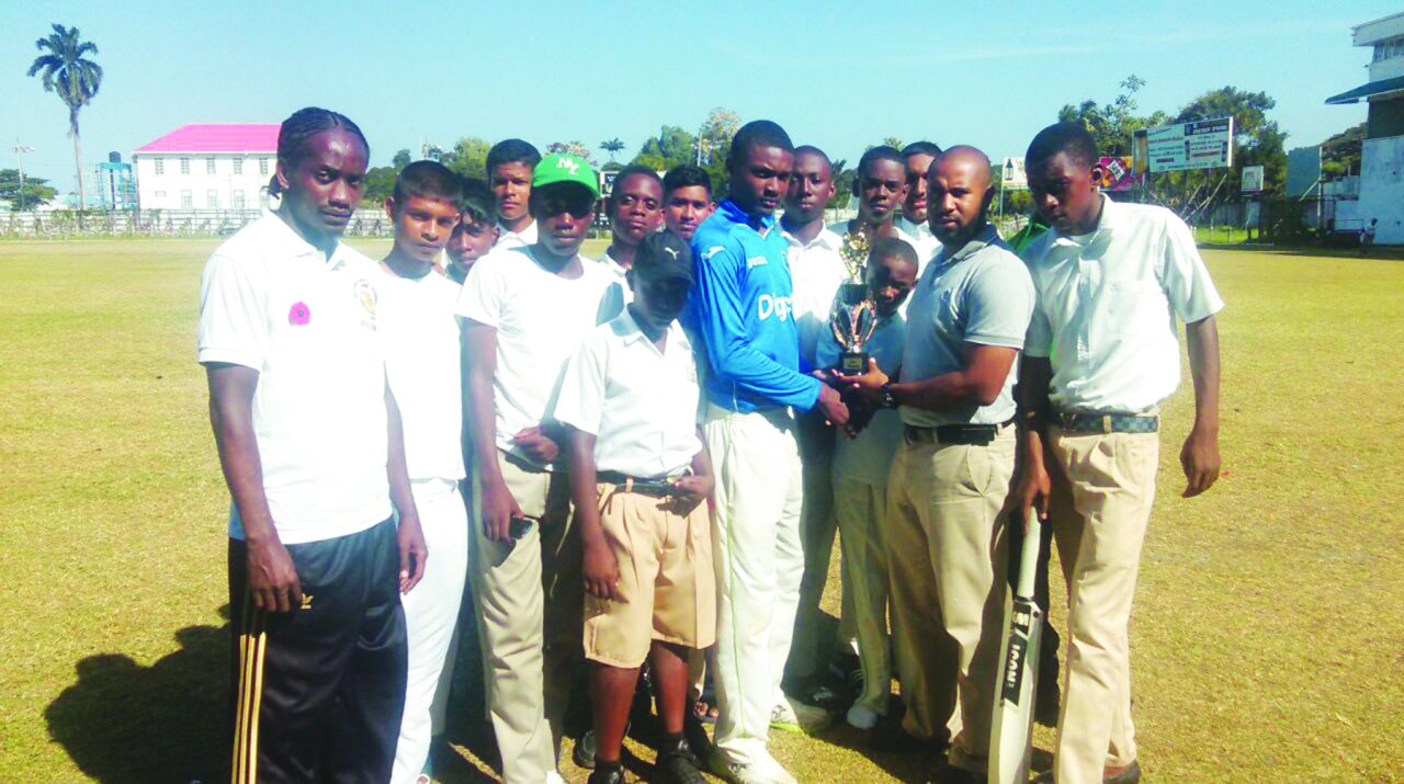 Anthony D'Anrade (second from right ) hands over the winning trophy to the Charlestown Secondary School captain 