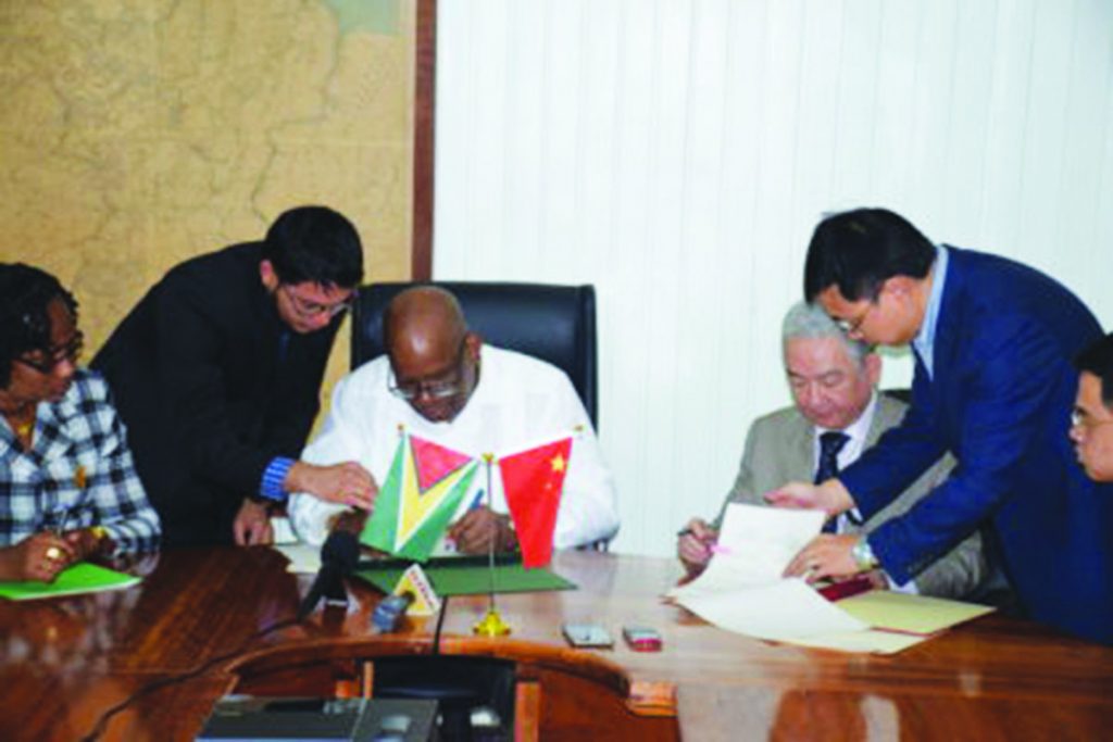 Finance Minister Winston Jordan and outgoing Ambassador of the People’s Republic of China, Zhang Limin signing the Framework Agreement