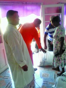 Swami assisting an elder with his hamper