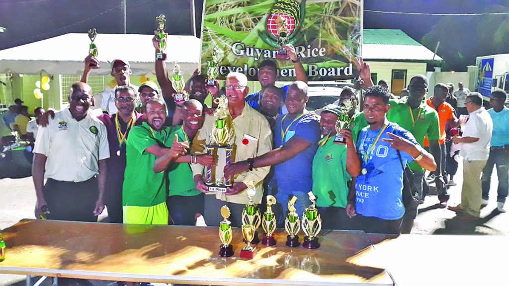 Agriculture Minister Noel Holder (centre) presenting the winning trophy to the cricket champions, the Guyana Rice Development Board 