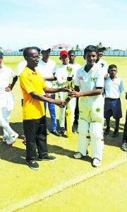 In the presence of his teammates, Captain of Number Eight Secondary, Nigel Deodat, receives the winning trophy from GCB representative David Black 