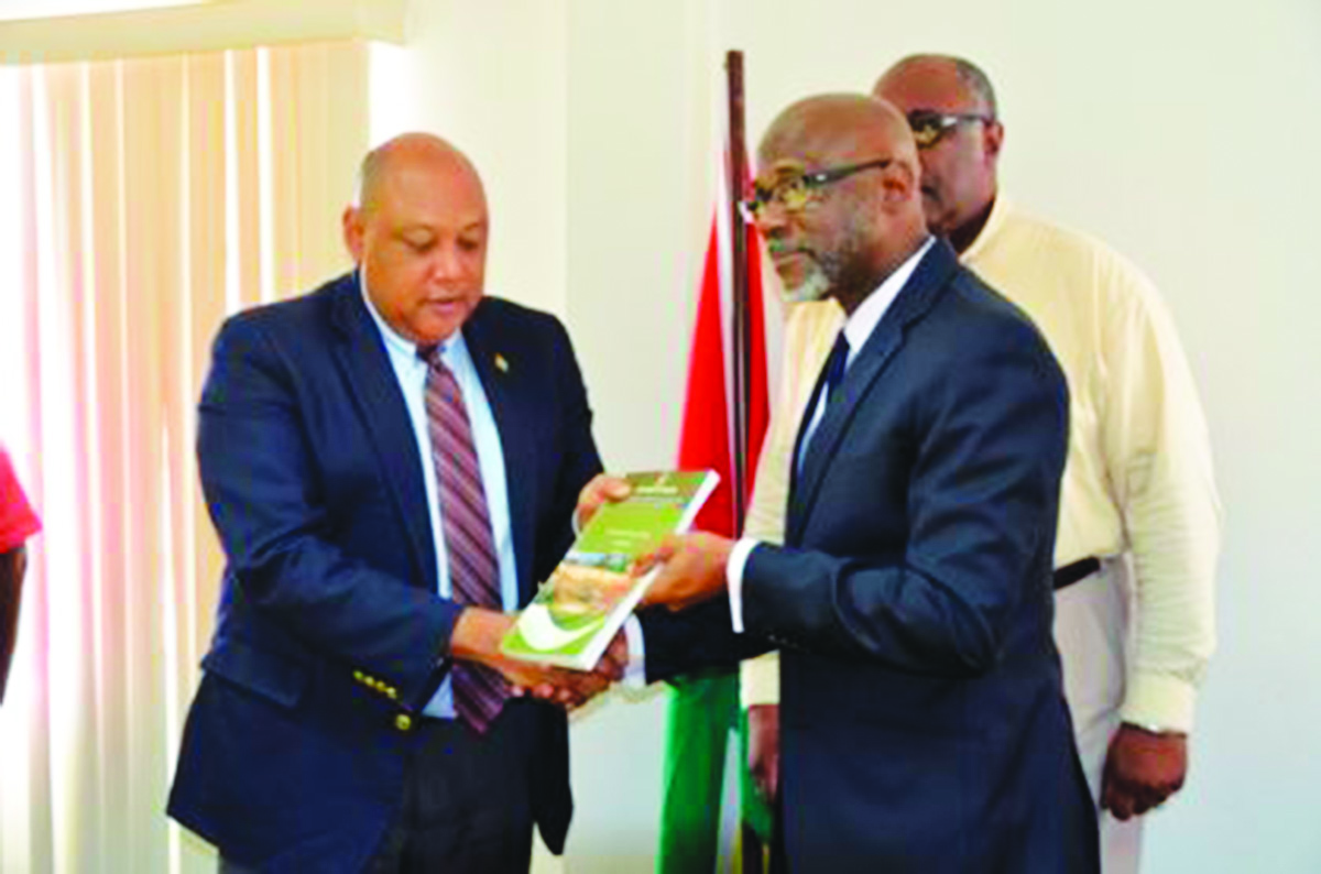 Natural Resources Minister Raphael Trotman receives the interim report from Rear Admiral (retired) Gary Best