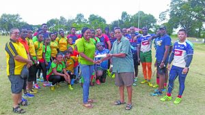 Vice President of the GOA, Noel Adonis presenting the sponsorship cheque to Secretary of the union, Petal Grant Saturday in the presence of the players and President Peter Green (extreme left)