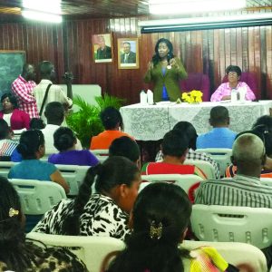 Minister within the Communities Ministry, Valerie Sharpe-Patterson addressing beneficiaries in the boardroom of the RDC at Anna Regina. Seated is Regional Vice Chairperson Nandranie Coonjah 
