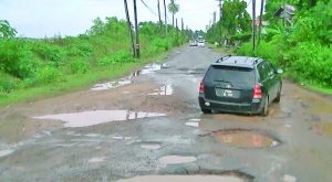 Vehicles manoeuvring around holes along the East Bank Berbice Road 