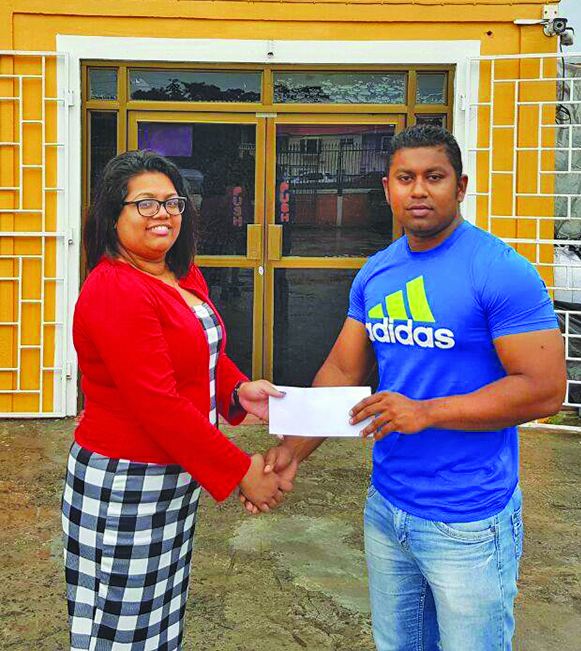 Atlantic Marine Supplies’ Emily Singh proudly hands over the sponsorship cheque to organiser of the event Videsh Sookram 