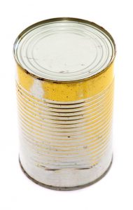 Unlabelled unopened can of processed preserved food, high angle view on white