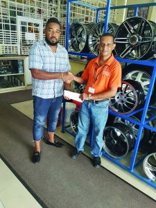 New Era Entertainment Director Kennrick Noel receiving a sponsorship cheque from Technical Executive of Tony’s Auto Spares, Lakeram Prabudial 