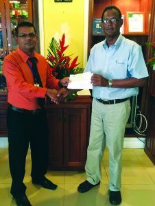 Manager of Grand Coastal Hotel, Ramesh Taykoo (left), hands over sponsorship cheque to LGC Vice President,  Patricik Prashad