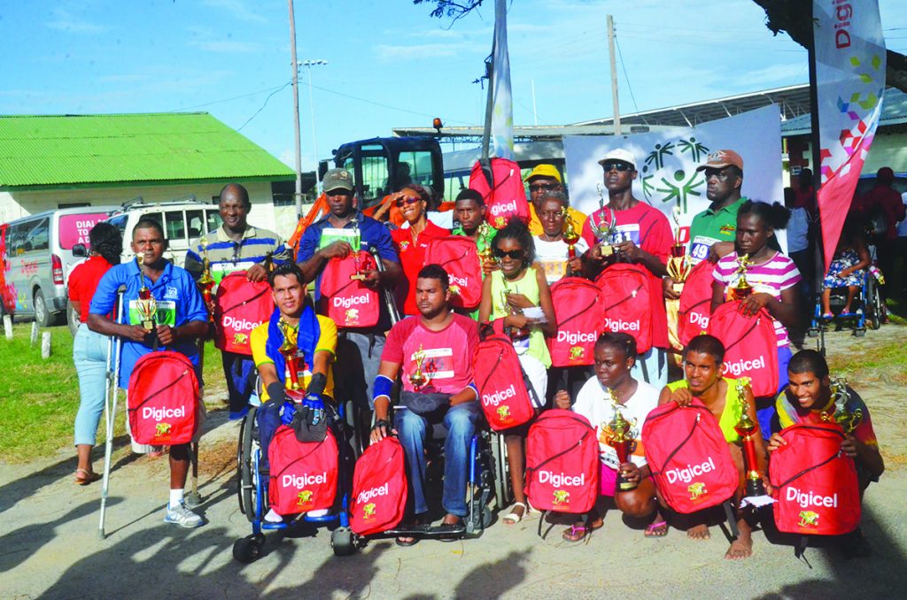 Winners all the way! The happy prize winners along with Jacquelin James (back row, red top) and Wilton Spencer (back row, yellow cap) at the closing ceremony of the 5k walk, run, wheel, for persons with disabilities in the national park on Sunday