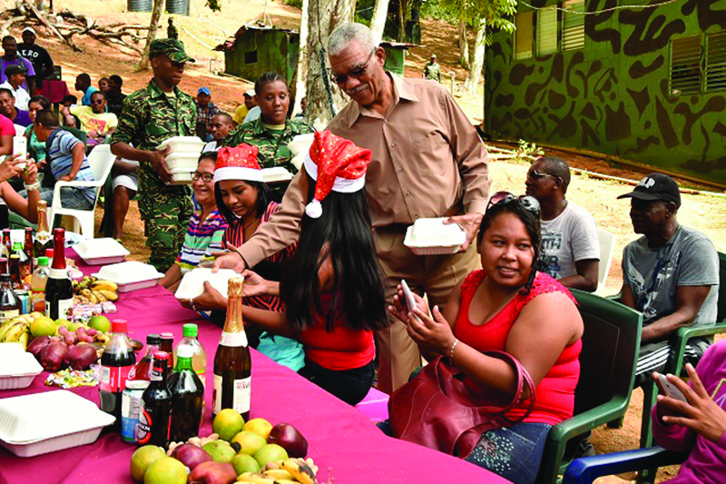 President Granger serves lunch to some of the nearby villagers who were invited to the annual Christmas lunch today at Eteringbang, Region Seven  