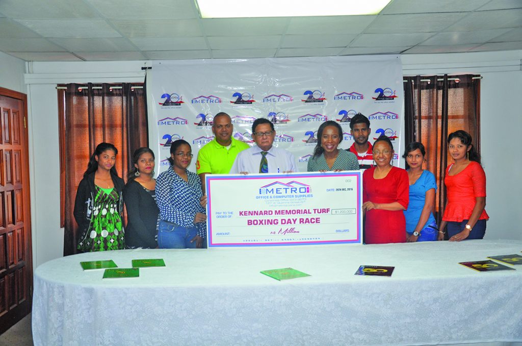 Metro Office and Computer Supplies Chief Executive Officer, Avia Lindie fifth from right hands over the sponsor cheque to President of KMTC Cecil Kennard sixth from right 