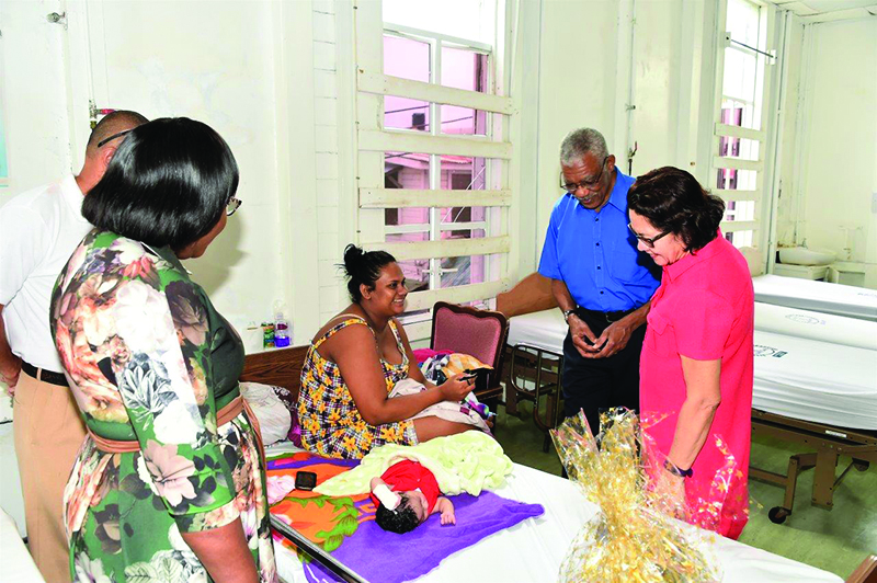 President David Granger and First Lady Sandra Granger take a moment to admire this Christmas baby who is sleeping peacefully 