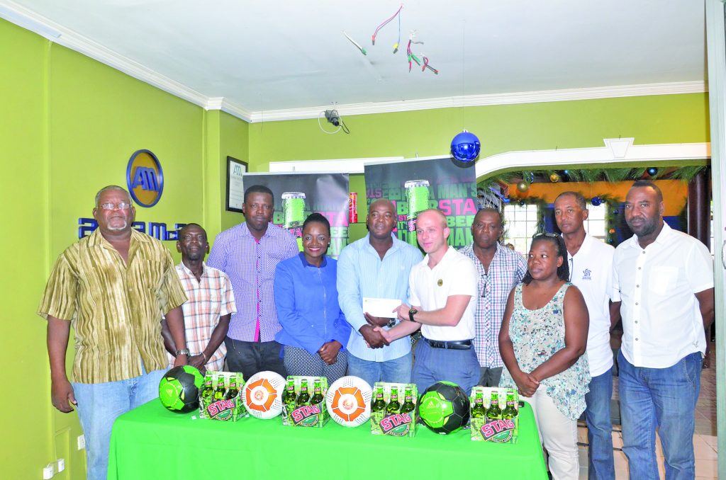 Bevrage Manager Robert Hiscock does the ceremonial sponsorship handover to EBFA President Franklyn Wilson, while GFF Vice-President Thandi McCallister (blue top) along with representatives from various associations look on 