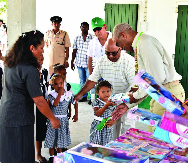 Prisident David Granger distributing toys at Caria Caria