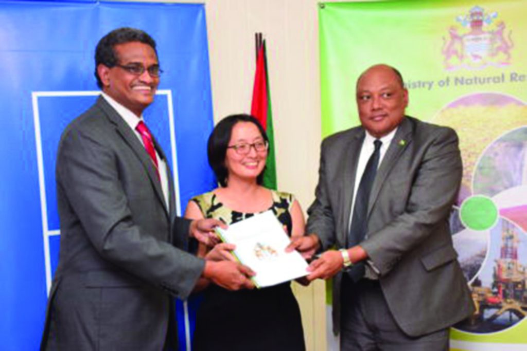 Natural Resources Minister Raphael Trotman receives the readiness assessment report from Principal Consultant of the Association of Caribbean Energy Specialists, Anthony Paul and UNDP Resident Representative, Mikiko Tanaka