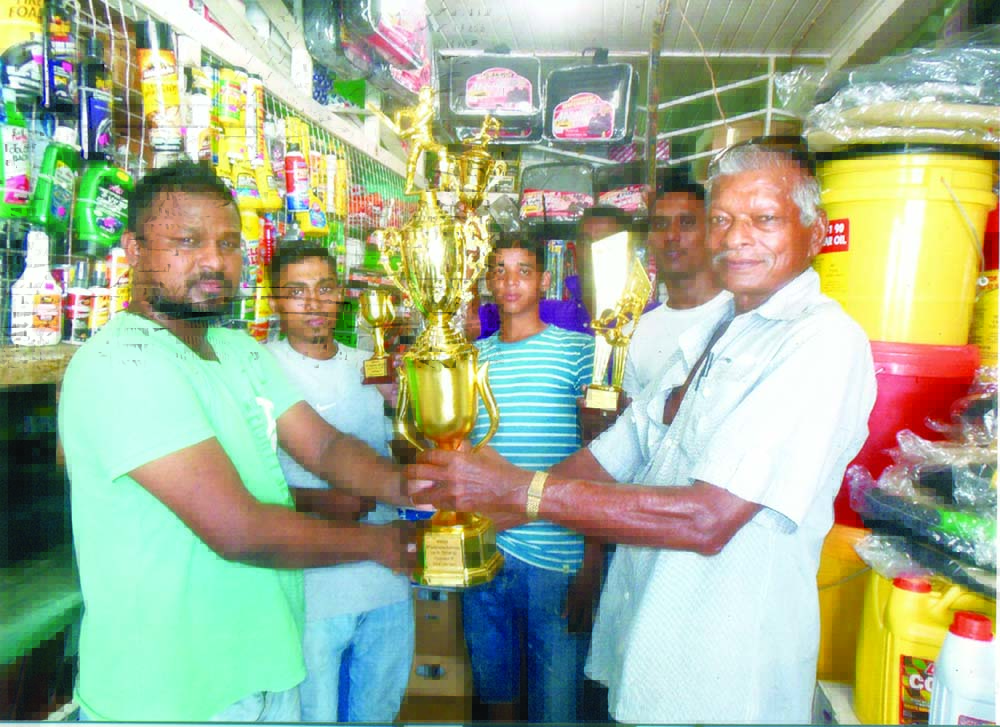 Manager of Derick’s Auto Spares, Anand Chintaman (left) hands over the winning trophy to Humanchal Mangra 