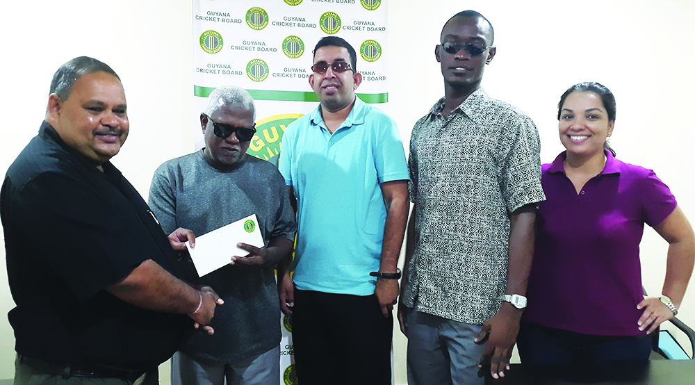 GCB president Drubahadur (left) presents the cheque to GBCA President Cecil Morris in the presence of players Ganesh Singh (centre) and Leroy Phillips (second right) while Melinda Bishundyal Chaitram of the GCB looks on