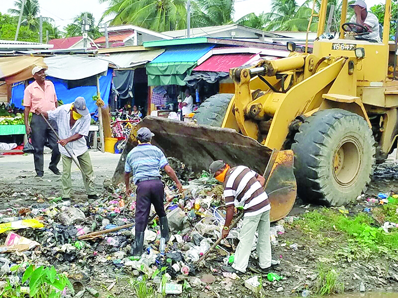 Persons assisting in clearing up the garbage which was indiscriminately dumped by vendors and residents