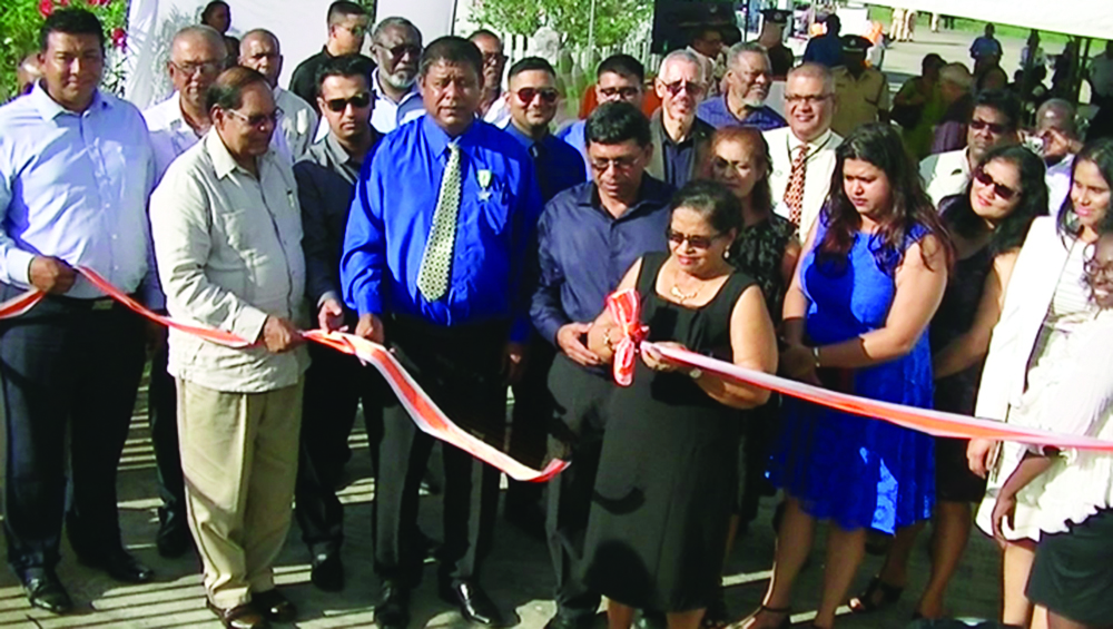 Prime Minister Moses Nagamootoo assisting with the cutting of the ribbon to commission the Green Energy System