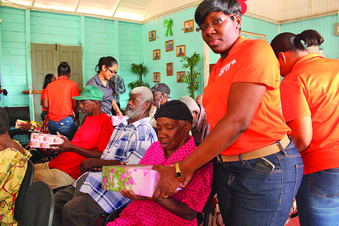 A GTT staff presenting a gift to a resident 
