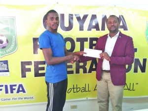 Delon Lanferman receives a timely donation from GFF President, Wayne Forde