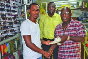 Gregory Richardson collects his prize from Junior’s Jewellery and Gift Gallery proprietor Ferdinand Bacchus