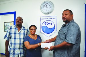 (L-R) RHTY&SC Executive Member Sohan Henry watches on as GWI Director of Human Resources, Management and Development Gale Doris hands over the sponsorship to CEO Hilbert Foster 