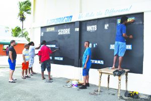 Everest Cricket Club executives repainting the scoreboard last Sunday  