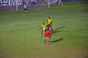 Western Tigers (yellow and black) and New Amsterdam United players engaged in a tussle for ball possession 