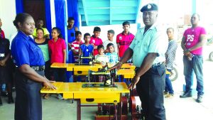 A rank accepts the machine on behalf of a group from G Division Commander Khali Pareshram and a beneficiary during the presentation ceremony  