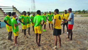 The national beach football team in a discussion prior to a training session at the Bayrock Beach Soccer Facility in Linden