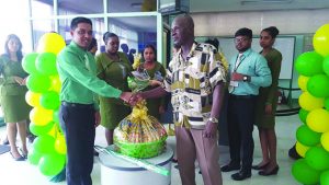 Branch Manager Devendra Persaud presenting a hamper 