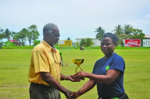 Player-of-the-match Akazie Thompson, right, receives her trophy from Match-Referee Grantley Culbard 