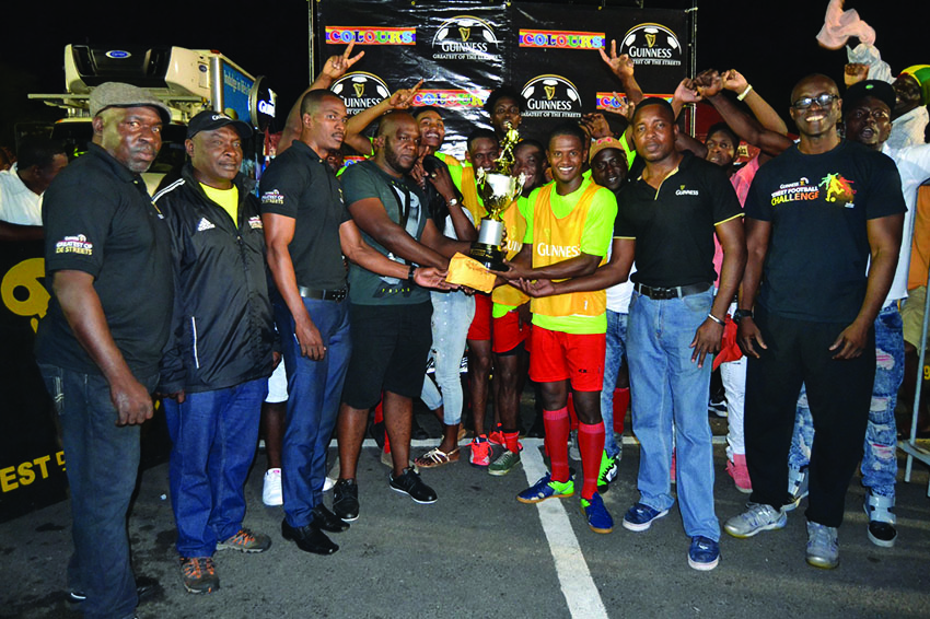 Captain of Showstoppers Hubert Pedro (centre) collects the championship trophy and prize money from Guinness representative Robeson Brotherson in the presence of teammates and Banks DIH Limited members 