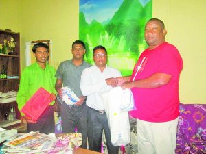 Club Secretary Hilbert Foster hands over donation to Sir Rohan Etwaru of PMSS, in the presence of other teachers 