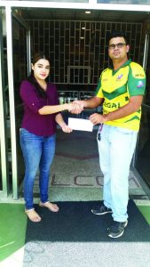 Nirmala Sukhram (left) hands over sponsorship to Videsh Persaud at Prem’s Electrical Store on Friday  