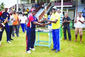 Veteran Divakanand “Vicky” Ramsaywack (left) collects the winning trophy from Ogle CC executive member David Harper