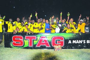 The victorious Western Tigers receive their winning trophy from ANSA McAL Trading’s Managing Director Troy Cadogan 