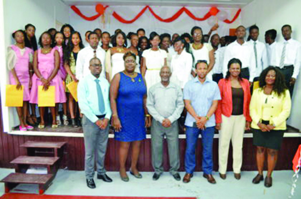 From left to right in front row: BIT Technical Officer Richard Maughn; Assistant Director National Community Development Council Sandra Adams; Minister within the Ministry of Social Protection, Keith Scott; Region 10 MP Jermaine Figueira; Assistant Director of Youth Leslyn Boyce; along with the 69 graduates of the BIT Youth Empowerment training project