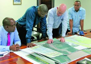 In photo, Arie Mol (second right) highlights location information to Public Infrastructure Minister David Patterson (second left), Ministerial Advisor Kenneth Jordan (right), and DHBC General Manager Rawlston Adams 