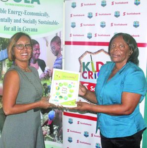 Marketing Manager of Scotiabank, Jennifer Cipriani hands over booklets to GEA Deputy CEO, Gayle Primo-Best 